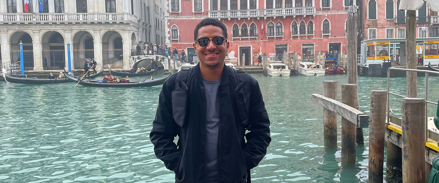 a student standing in Venice by the river