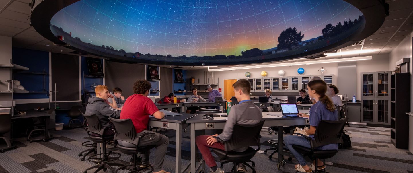student in a large classroom planetarium