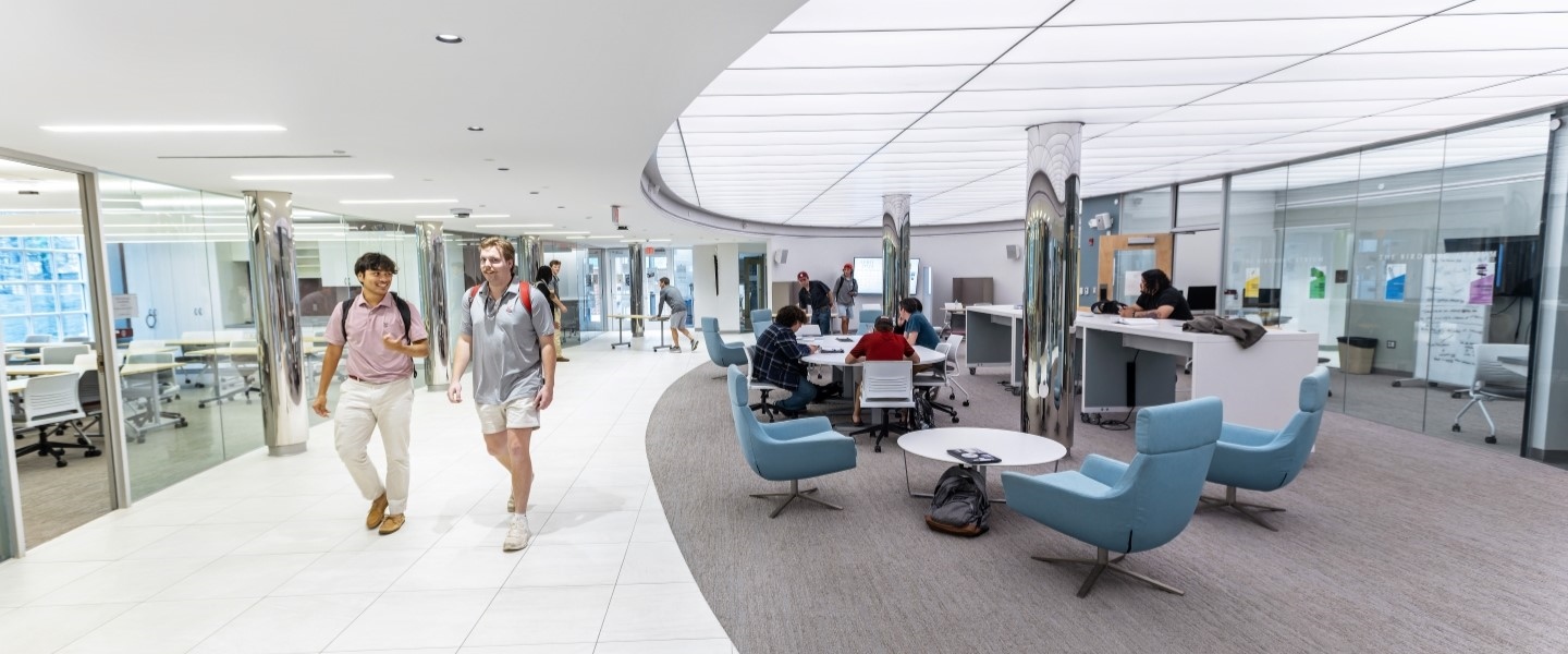 students walking through a glass building in the communications center