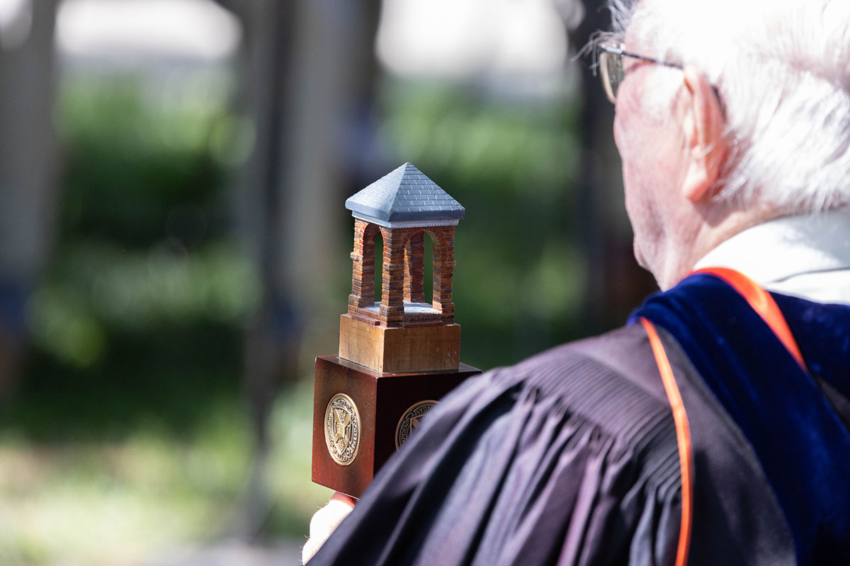 Faculty professor in regalia leading the procession