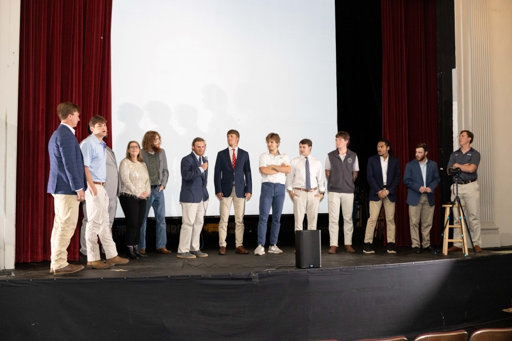 student presenters standing together onstage
