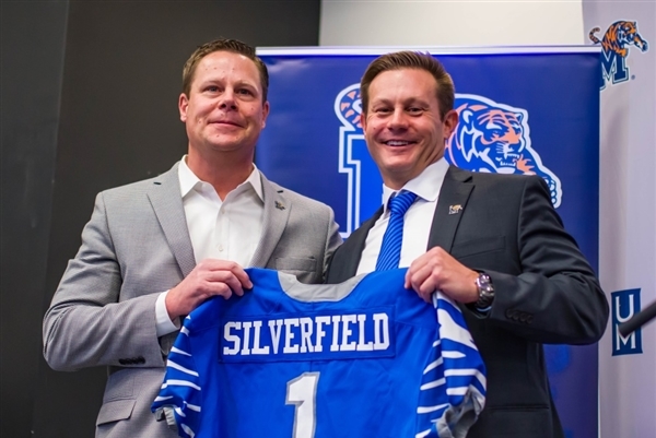 Coach Ryan Silverfield holding a football jersey