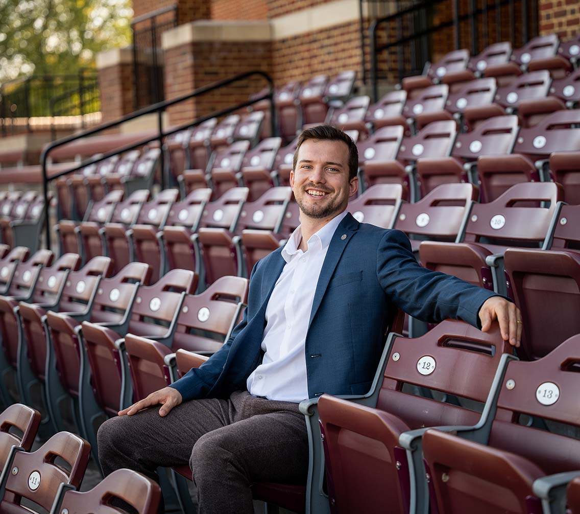 Mike Daum '23 standing next to an eagle statue