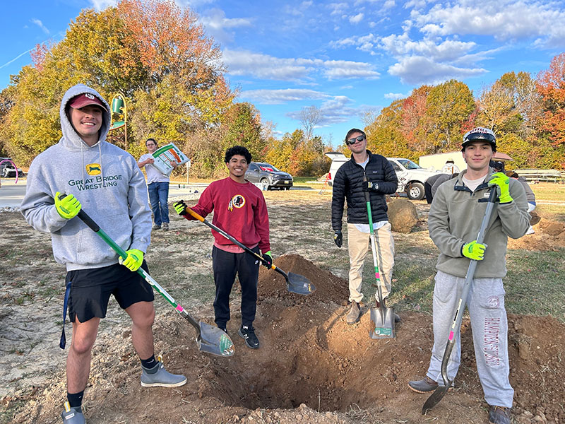 students planting trees at a park