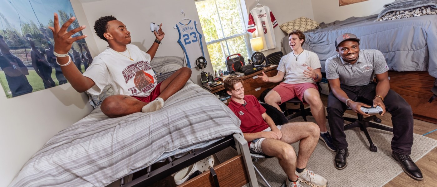 Students hanging out in their dorm room laughing and talking