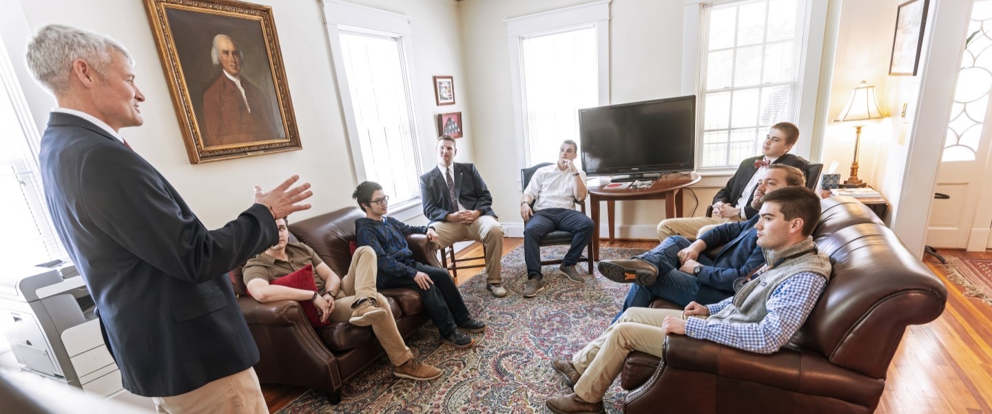 Vinton Bruton speaking to his class in a living room setting